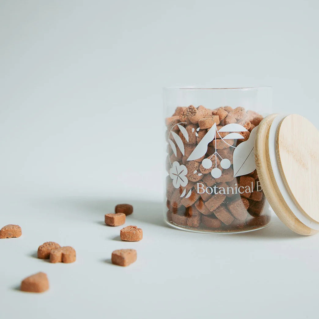 Botanical Bones - LOVE BITES Treats heart-shaped crunchy peanut butter dog cookies in a glass jar with wooden lid.