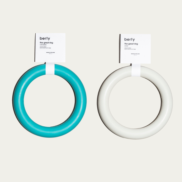 Two circular-shaped Berty 'The Great Ring' dog toys in turquoise and oyster colors, made from natural rubber. These durable, eco-friendly rings are perfect for chew and toss play, ideal for eco-conscious dog owners seeking sustainable, high-quality dog accessories that promote exercise and wellness.