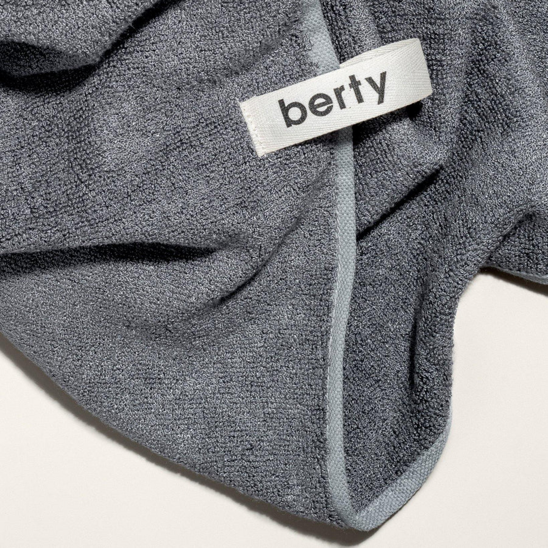 Close-up of a soft, dark stone-colored antibacterial bath towel for dogs, featuring a 'berty' label. Made from eco-friendly, 100% bamboo material, this high-quality towel is perfect for sustainable pet care and natural dog grooming. Ideal for conscious dog parents seeking a luxurious and practical addition to their dog's wellness routine.